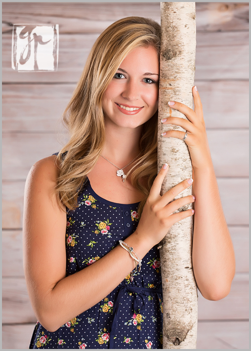 high school senior leaning against a tree