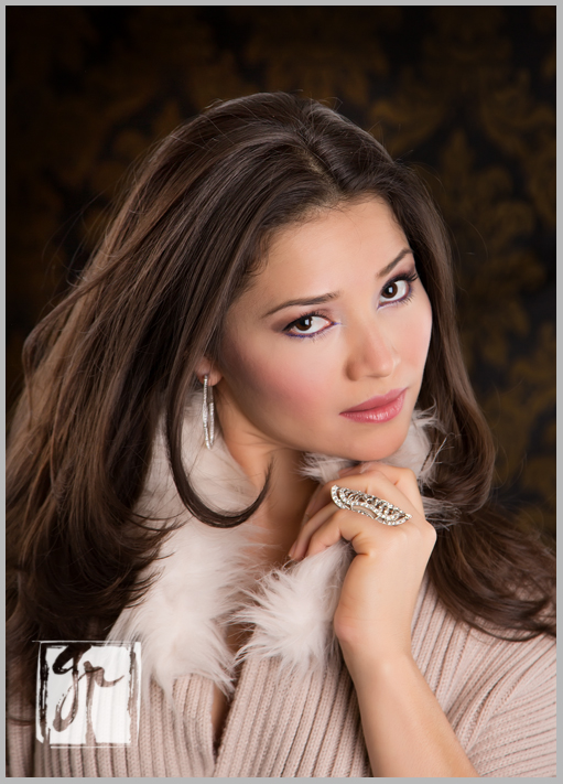 Glamorous brunette holds fur collar and wears silver ring